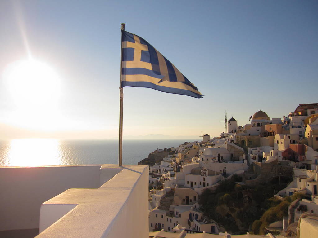 View of Santorini and the Greek Flag Waving